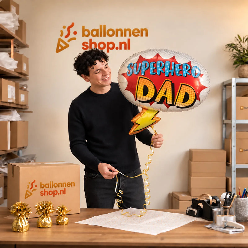 Jesse houdt de Superhero Dad Helium Ballon vast in de warme inpakruimte van Ballonnenshop.nl.