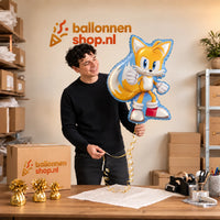 Jesse houdt de Tails Sonic Helium Ballon vast in de warme inpakruimte van Ballonnenshop.nl.
