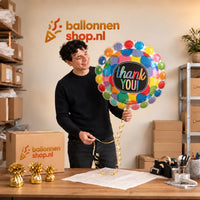 Jesse houdt de Thank You Helium Ballon vast in de warme inpakruimte van Ballonnenshop.nl.