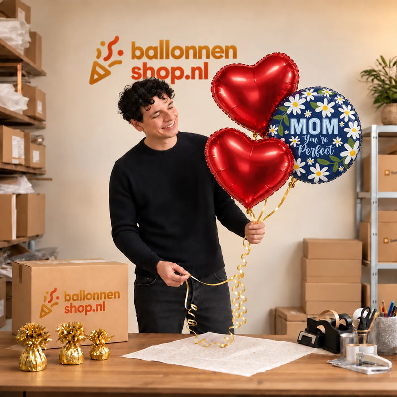 Jesse houdt Mom You're Perfect Trosje vast in de warme werkplaats van Ballonnenshop.nl.