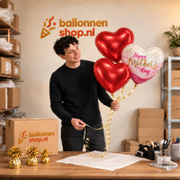 Jesse houdt Mother's Day Pretty Pink Tros vast in de warme werkplaats van Ballonnenshop.nl.
