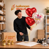 Jesse houdt Liefste Mama Trosje Ballonnen vast in de warme werkplaats van Ballonnenshop.nl.