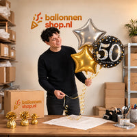 Jesse houdt 50 Jaar Trosje Zilver/Zwart/Goud vast in de warme werkplaats van Ballonnenshop.nl.