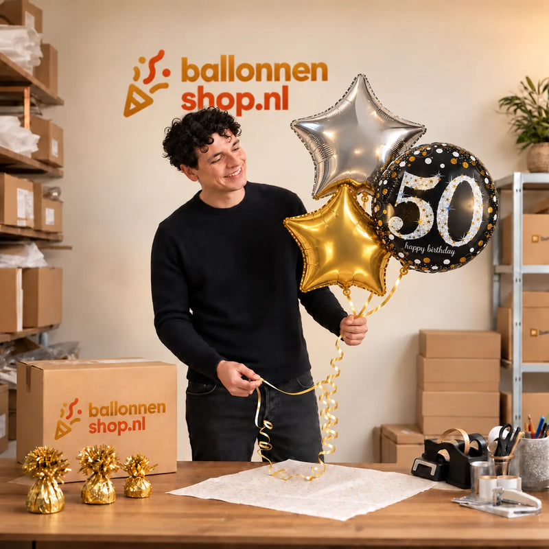 Jesse houdt 50 Jaar Trosje Zilver/Zwart/Goud vast in de warme werkplaats van Ballonnenshop.nl.