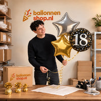 Jesse houdt 18 Jaar Trosje Zilver/Zwart/Goud vast in de warme werkplaats van Ballonnenshop.nl.