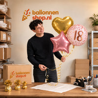 Jesse houdt 18 Jaar Trosje Roze/Goud/Rose Goud vast in de warme werkplaats van Ballonnenshop.nl.