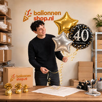 Jesse houdt 40 Jaar Trosje Zilver/Zwart/Goud vast in de warme werkplaats van Ballonnenshop.nl.