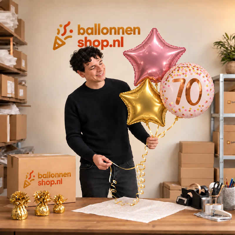 Jesse houdt 70 Jaar Trosje Roze/Goud/Rose Goud vast in de warme werkplaats van Ballonnenshop.nl.