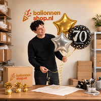 Jesse houdt 70 Jaar Trosje Zilver/Zwart/Goud vast in de warme werkplaats van Ballonnenshop.nl.