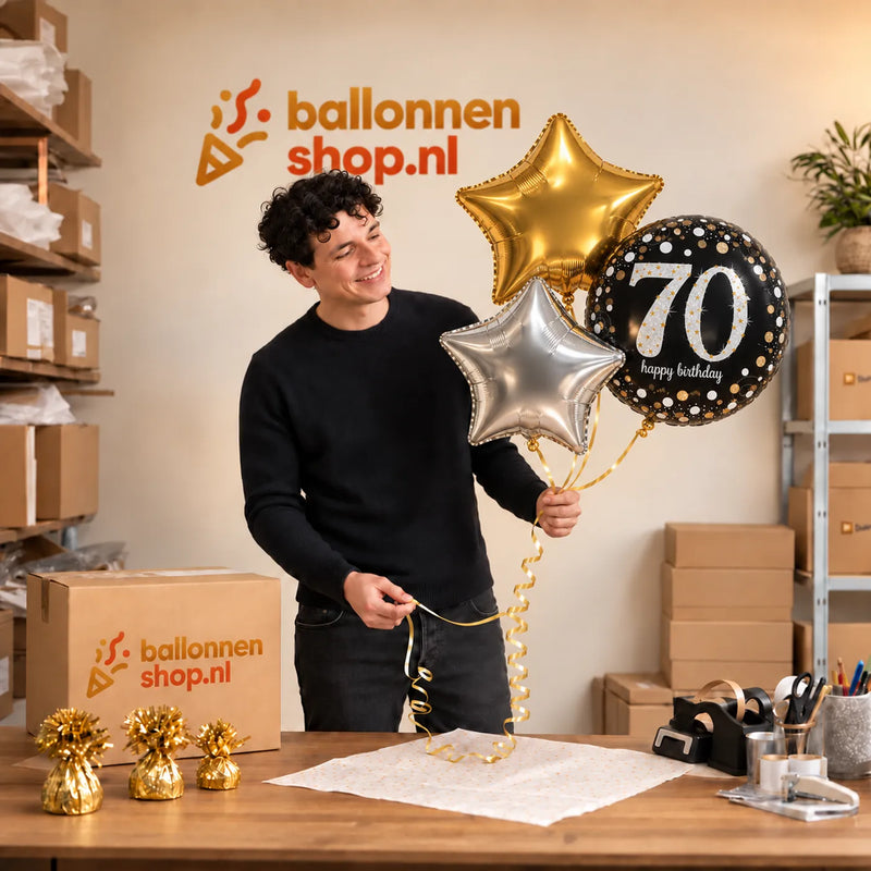 Jesse houdt 70 Jaar Trosje Zilver/Zwart/Goud vast in de warme werkplaats van Ballonnenshop.nl.