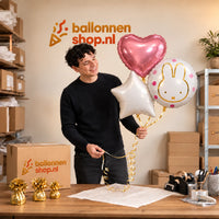 Jesse houdt Nijntje trosje Ballonnen Roze vast in de warme werkplaats van Ballonnenshop.nl.