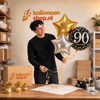 Jesse houdt 90 Jaar Trosje Zilver/Zwart/Goud vast in de warme werkplaats van Ballonnenshop.nl.