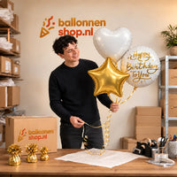 Jesse houdt Happy Birthday To You Trosje Wit/Goud vast in de warme werkplaats van Ballonnenshop.nl.