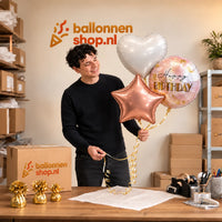 Jesse houdt Happy Birthday Trosje Rose Goud/Wit/Marmer vast in de warme werkplaats van Ballonnenshop.nl.
