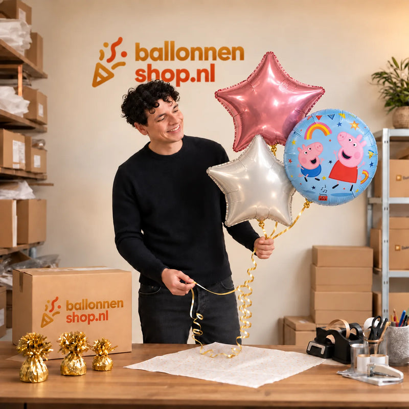 Jesse houdt Peppa Pig Trosje Wit/Roze/Blauw vast in de warme werkplaats van Ballonnenshop.nl.