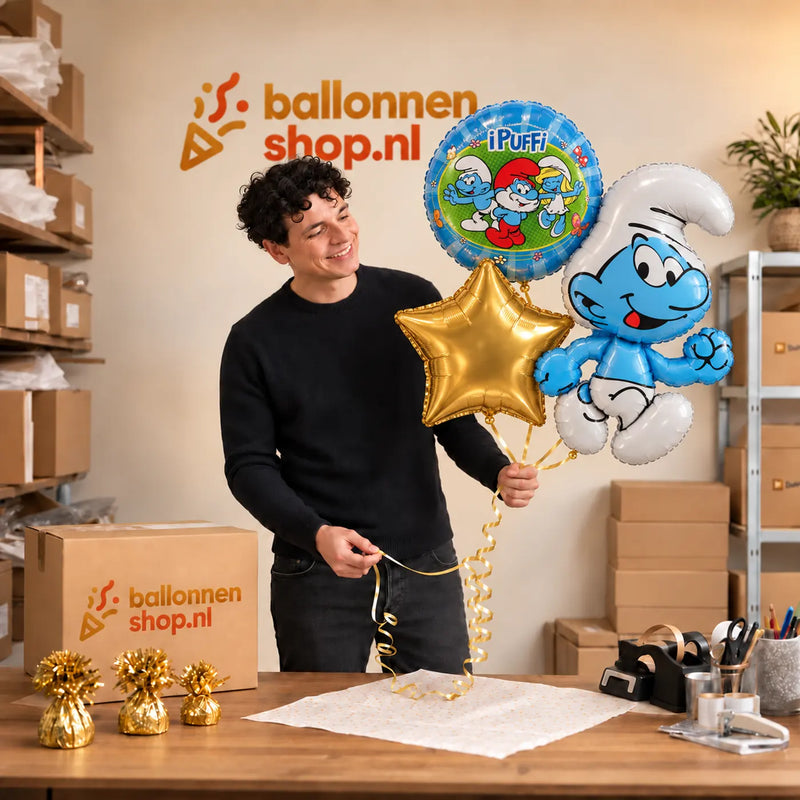 Jesse houdt Smurfen Trosje blauw/wit/groen vast in de warme werkplaats van Ballonnenshop.nl.
