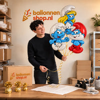 Jesse houdt Smurfen Trosje blauw/wit/rood/geel vast in de warme werkplaats van Ballonnenshop.nl.