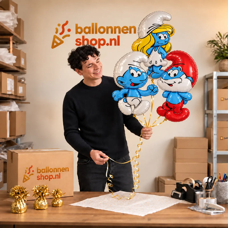 Jesse houdt Smurfen Trosje blauw/wit/rood/geel vast in de warme werkplaats van Ballonnenshop.nl.