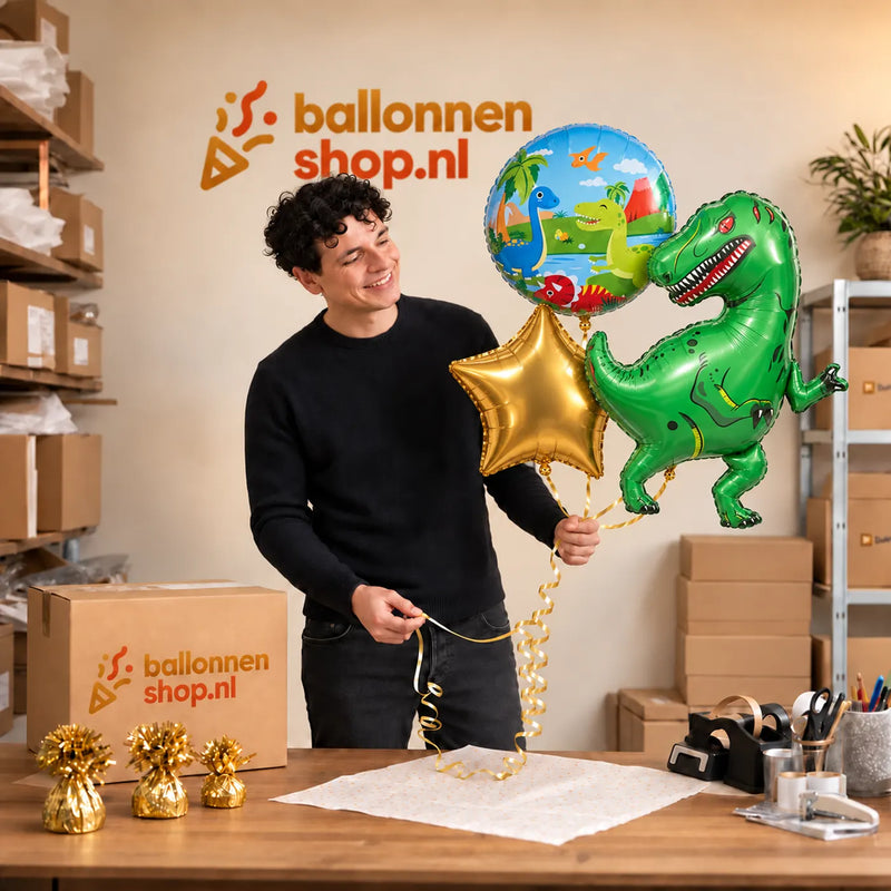 Jesse houdt Tyrannosaurus Rex Dino Trosje Goud/Blauw/Groen/Rood vast in de warme werkplaats van Ballonnenshop.nl.