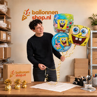 Jesse houdt Spongebob Trosje Blauw/Groen/Rood vast in de warme werkplaats van Ballonnenshop.nl.