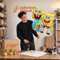 Jesse houdt Spongebob Trosje Goud/Blauw/Geel/Groen vast in de warme werkplaats van Ballonnenshop.nl.