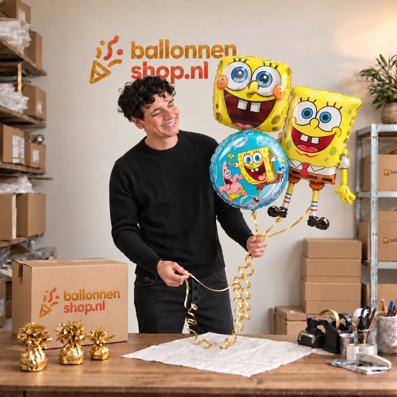 Jesse houdt Spongebob Trosje Goud/Blauw/Geel/Groen vast in de warme werkplaats van Ballonnenshop.nl.