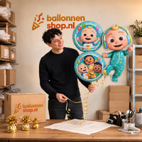 Jesse houdt Cocomelon Trosje Blauw/Wit/Groen – 76 cm vast in de warme werkplaats van Ballonnenshop.nl.