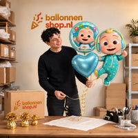 Jesse houdt Cocomelon Baby Trosje Blauw/Wit/Groen vast in de warme werkplaats van Ballonnenshop.nl.