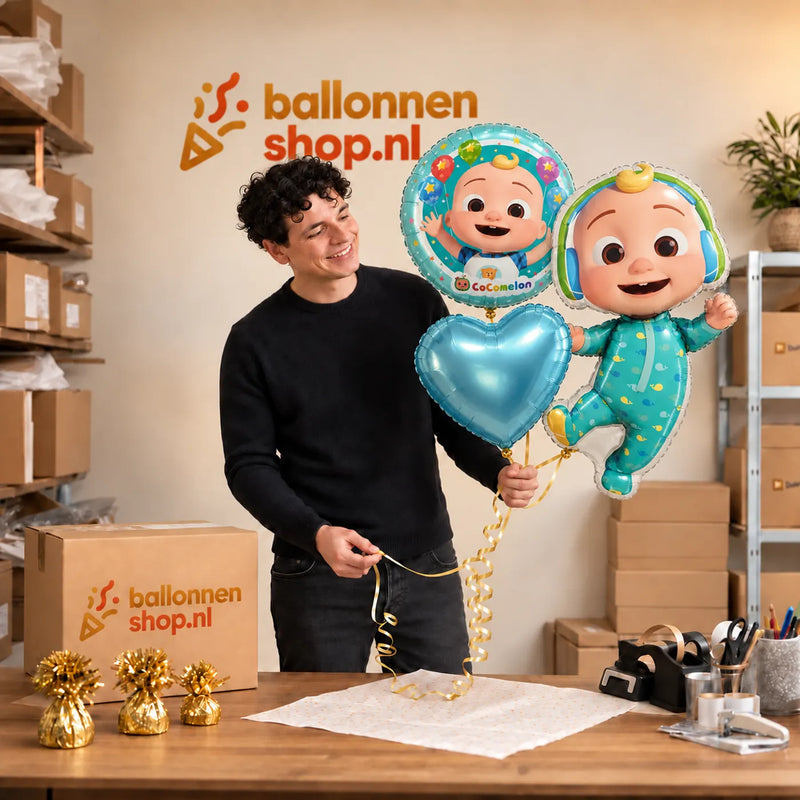 Jesse houdt Cocomelon Baby Trosje Blauw/Wit/Groen vast in de warme werkplaats van Ballonnenshop.nl.