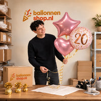 Jesse houdt 20 Jaar Trosje Roze/Rose Goud vast in de warme werkplaats van Ballonnenshop.nl.