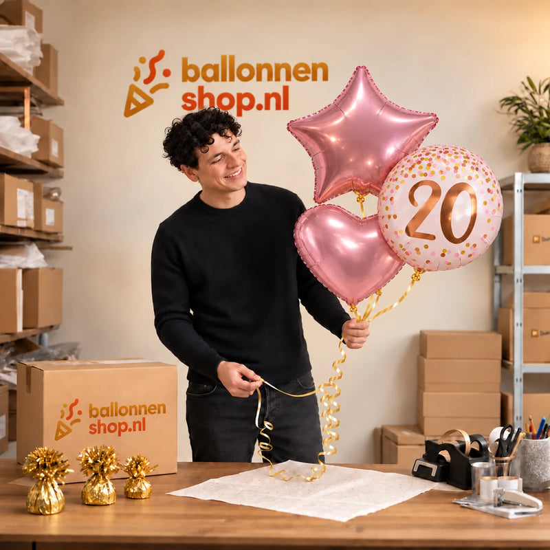 Jesse houdt 20 Jaar Trosje Roze/Rose Goud vast in de warme werkplaats van Ballonnenshop.nl.