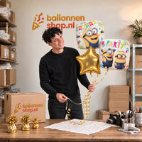 Jesse houdt Minion Verjaardags Trosje Geel/Wit/Goud vast in de warme werkplaats van Ballonnenshop.nl.