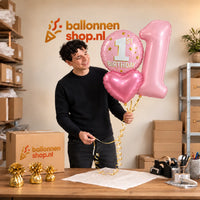 Jesse houdt 1 Jaar XL Trosje Roze vast in de warme werkplaats van Ballonnenshop.nl.