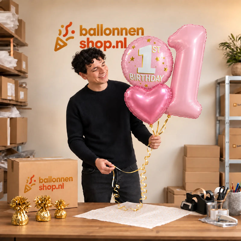 Jesse houdt 1 Jaar XL Trosje Roze vast in de warme werkplaats van Ballonnenshop.nl.