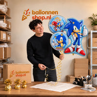 Jesse houdt Sonic Trosje – 84 cm vast in de warme werkplaats van Ballonnenshop.nl.