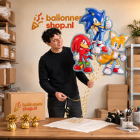 Jesse houdt Sonic, Knuckles en Tails Trosje vast in de warme werkplaats van Ballonnenshop.nl.