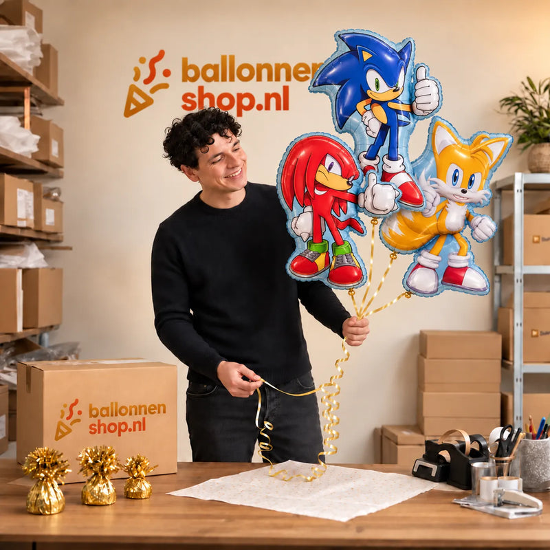 Jesse houdt Sonic, Knuckles en Tails Trosje vast in de warme werkplaats van Ballonnenshop.nl.