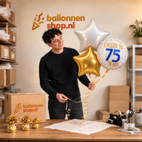 Jesse houdt 75 Jaar Trosje Wit/Goud/Blauw vast in de warme werkplaats van Ballonnenshop.nl.