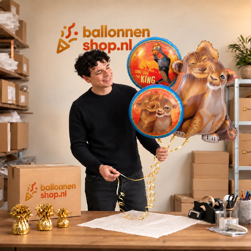 Jesse houdt Simba & Nala Lion King Trosje XL vast in de warme werkplaats van Ballonnenshop.nl.