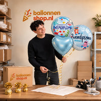 Jesse houdt Zwemdiploma Trosje Blauw vast in de warme werkplaats van Ballonnenshop.nl.
