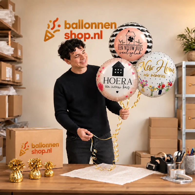 Jesse houdt Nieuw Huis Trosje Ballonnen vast in de warme werkplaats van Ballonnenshop.nl.