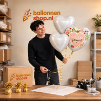 Jesse houdt 12.5 Jaar Getrouwd Hartjes Tros vast in de warme werkplaats van Ballonnenshop.nl.