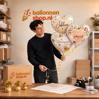 Jesse houdt 12.5 Jaar Getrouwd Trosje vast in de warme werkplaats van Ballonnenshop.nl.