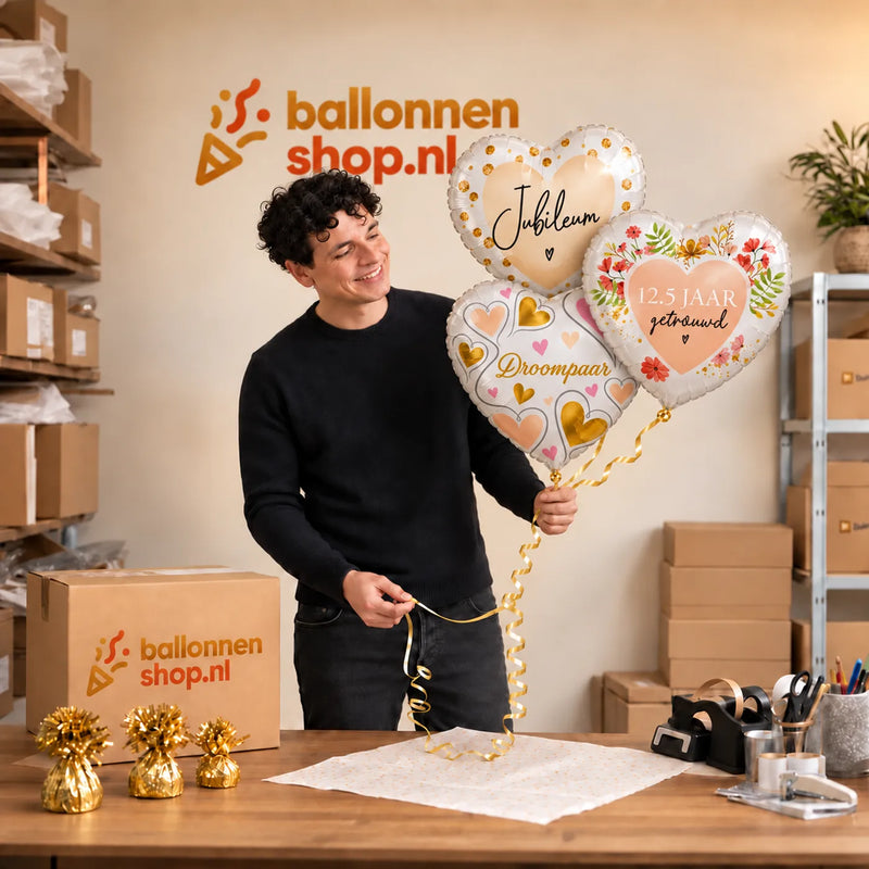 Jesse houdt 12.5 Jaar Getrouwd Trosje vast in de warme werkplaats van Ballonnenshop.nl.