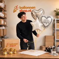 Jesse houdt Zilver 25 Jarig Huwelijk Trosje vast in de warme werkplaats van Ballonnenshop.nl.