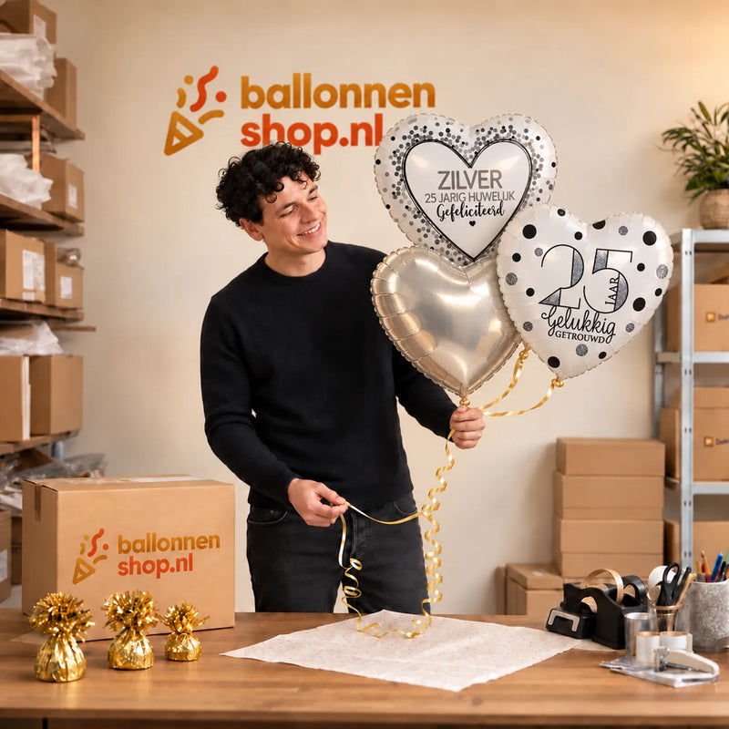 Jesse houdt 25 Jaar Getrouwd Trosje Zilver vast in de warme werkplaats van Ballonnenshop.nl.