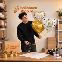 Jesse houdt 50 Jaar Getrouwd Trosje Goud vast in de warme werkplaats van Ballonnenshop.nl.