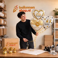 Jesse houdt 50 Jarig Huwelijk Trosje Goud vast in de warme werkplaats van Ballonnenshop.nl.