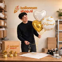 Jesse houdt Hoera Getrouwd Trosje Ballonnen vast in de warme werkplaats van Ballonnenshop.nl.