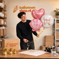 Jesse houdt Bride To Be Trosje Ballonnen vast in de warme werkplaats van Ballonnenshop.nl.